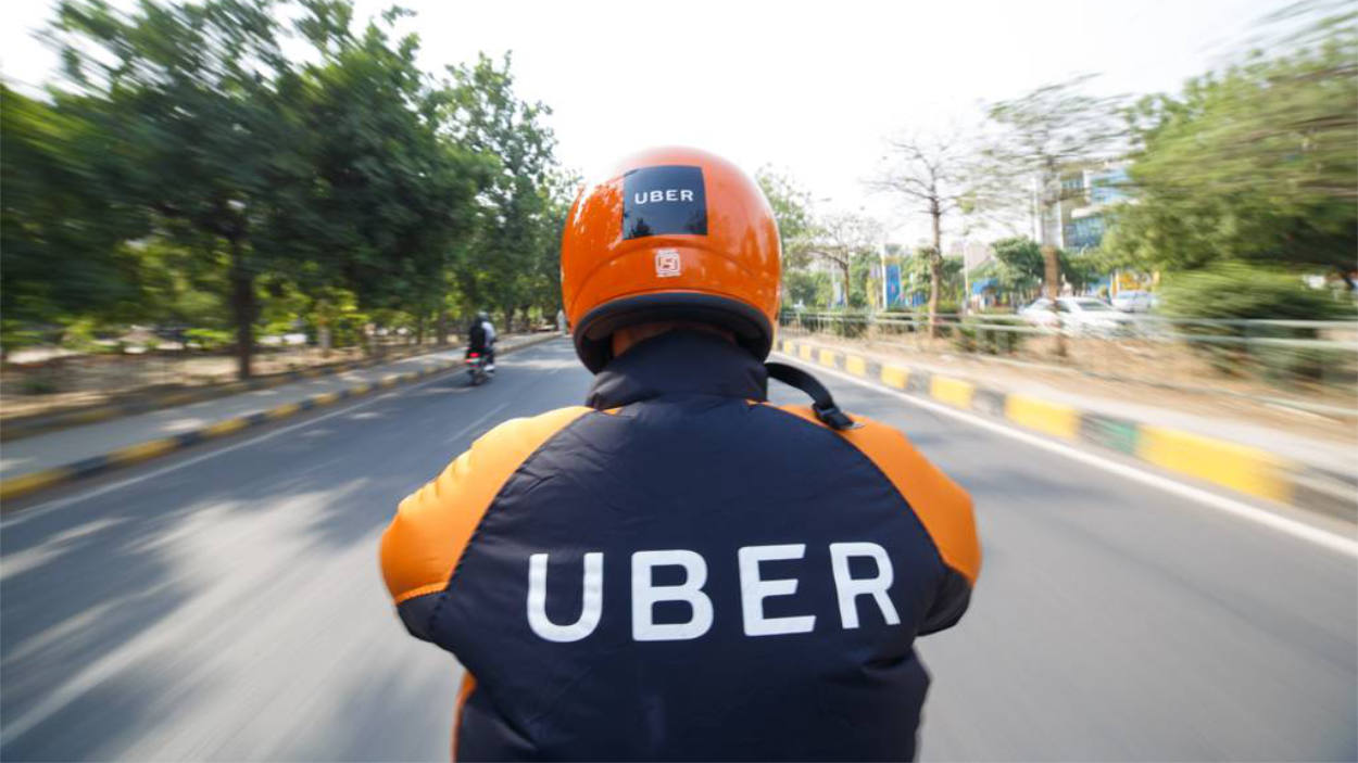 Uber Moto rodando na cidade com camisa da empresa